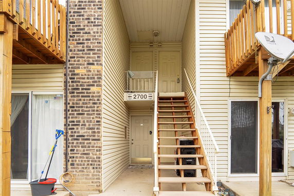 Front view of a multi-unit residential building with outdoor stairs.