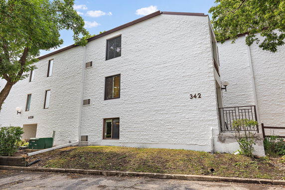 Front view of a multi-story white brick building with several windows.