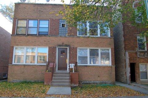 Front view of a two-story brick building with large windows and a central entrance.
