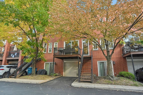Front view of a residential building with multiple balconies and garages.