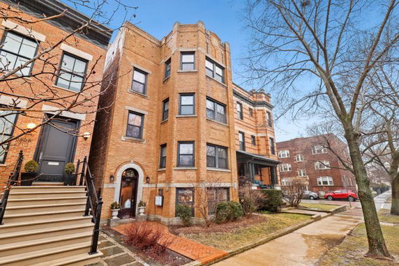 Front view of a multi-story brick building with a unique architectural design.