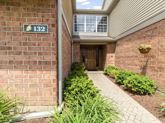 Entryway of a house with brick walls and a wooden door.