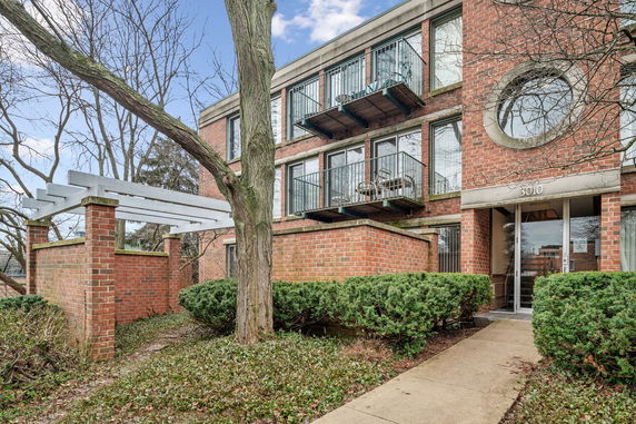 Front view of a brick apartment building with balconies.