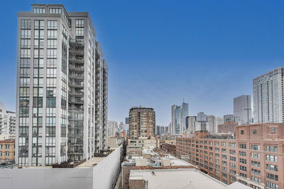 Urban skyline with several high-rise buildings and a clear blue sky.