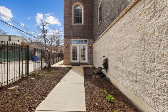 Front view of a building with a pathway leading to the entrance and a brick exterior.