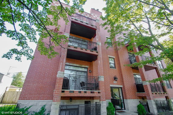 Front view of a multi-story brick building with balconies.