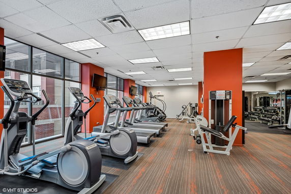Interior view of a gym with various exercise equipment and treadmills.