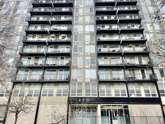 Front view of a multi-story apartment building with balconies.