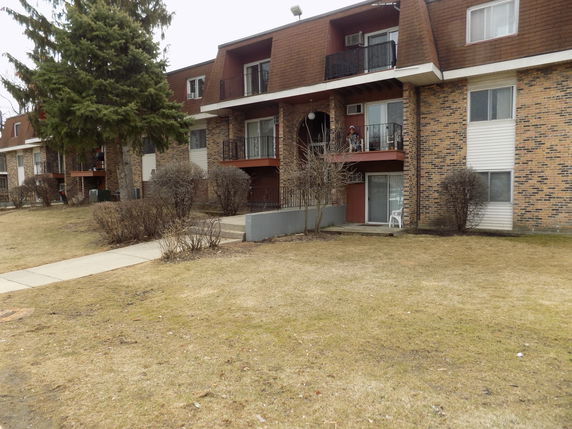 Front view of a multi-story apartment building with balconies.