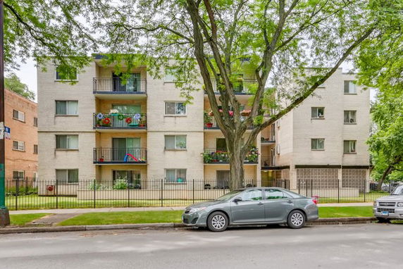 Front view of a multi-story apartment building with balconies.