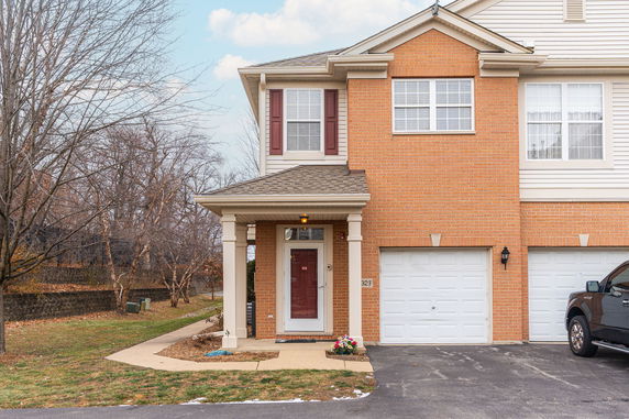 Front view of a two-story house with a brick facade and attached double garage.
