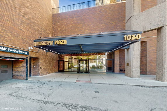 Front view of a commercial building with a glass entrance and brick exterior.