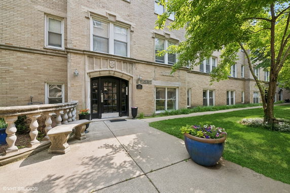 Front view of a multi-story brick building with an arched entrance.