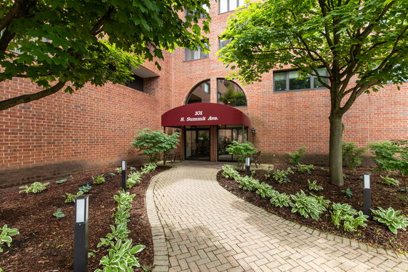 Front view of a brick building with a red canopy entrance.