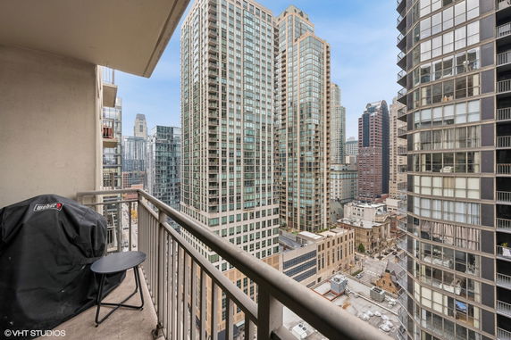 View from a balcony overlooking a cityscape with multiple tall buildings.