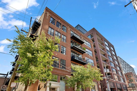 Front view of a multi-story brick building with balconies.