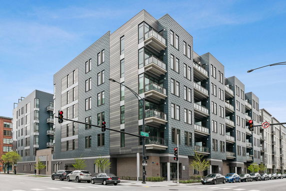Front view of a modern multi-story apartment building with balconies.