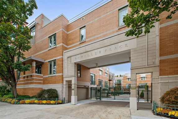 Front view of a multi-story building with an open archway entrance and brick exterior.