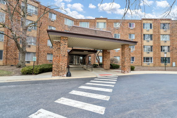 Front view of a multi-story brick building with a covered entrance.