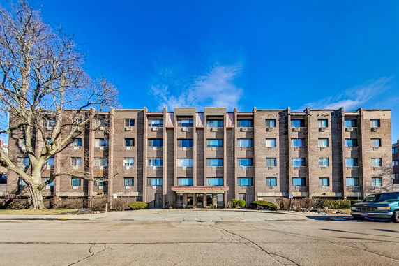 Front view of a multi-story brick apartment building.