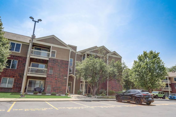 Front view of a multi-story residential building with brick and siding facade.