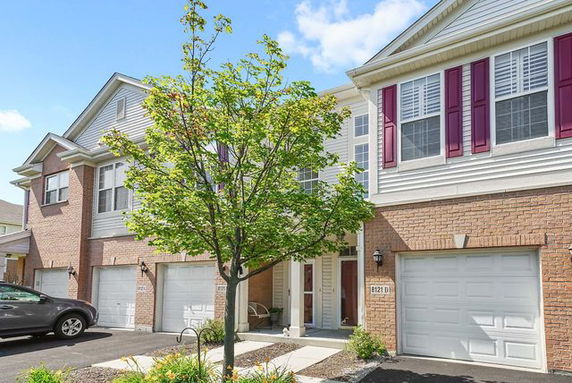 Front view of two-story townhouse with double garage and brick exterior.