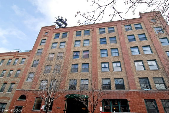 Front view of a multi-story brick building with numerous windows.