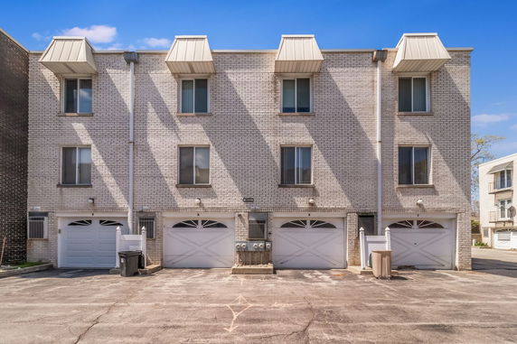 Front view of a three-story building with three garage doors.