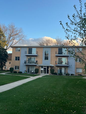 Front view of a three-story apartment building with balconies.