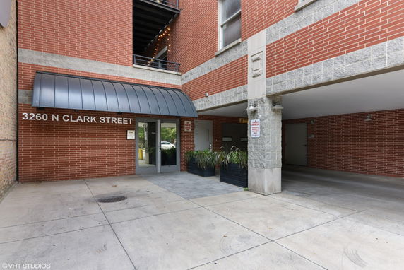 Front view of a building entrance with red brick exterior and a covered entryway.
