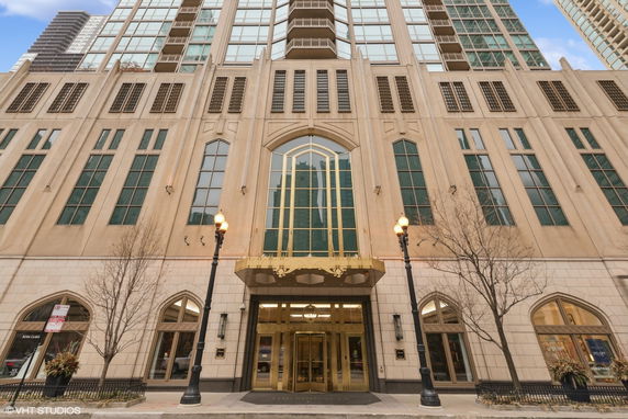 Front view of a large multi-story building with tall windows and ornate entrance.