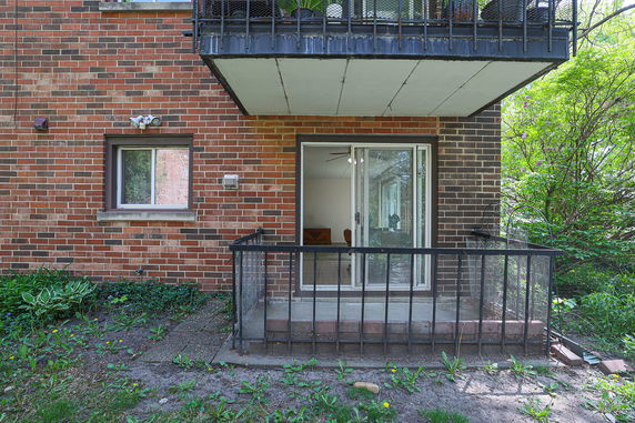 Front view of a building with a small balcony and sliding glass door.