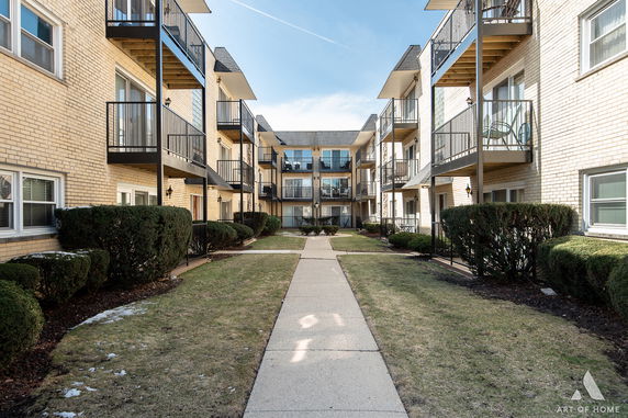 Front view of a multi-story apartment building with balconies.