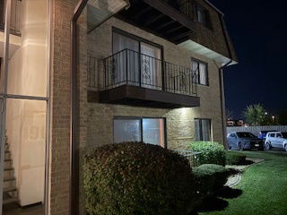 Night view of a two-story building with brick exterior and balconies.