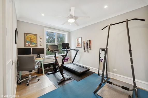 Indoor gym area with exercise equipment and a desk.