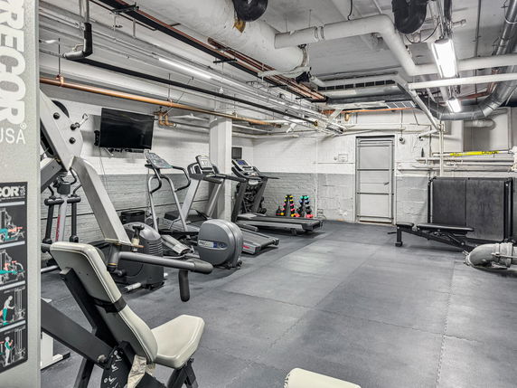 Indoor gym area with exercise equipment and workout machines.