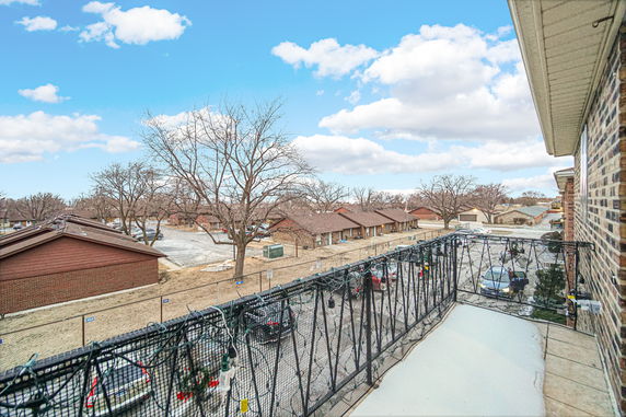 Panoramic view from a building showcasing a residential area with multiple houses and parked cars.