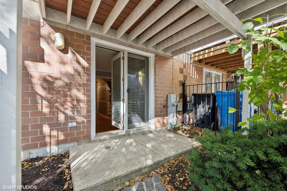 Rear view of a brick building entrance with a concrete patio.