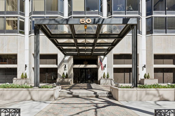 Front view of a modern building with a glass canopy entrance.