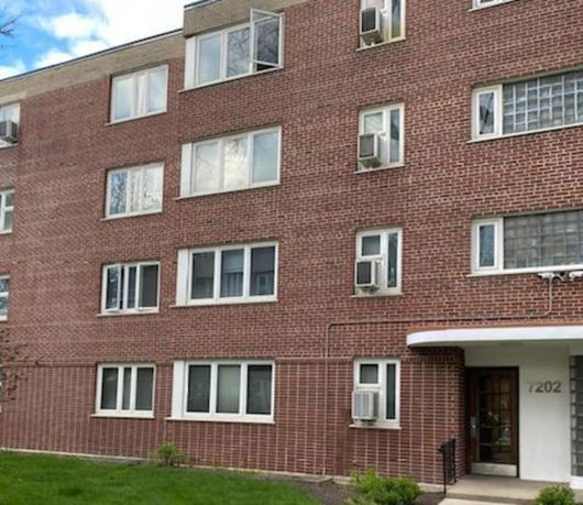 Front view of a multi-story brick apartment building.
