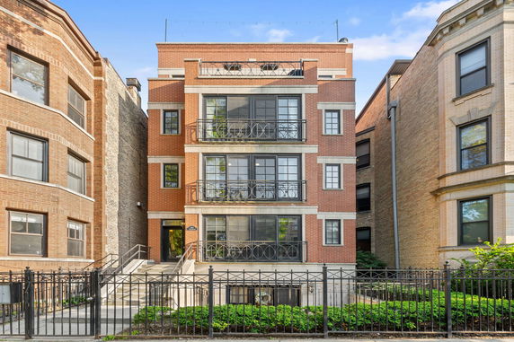 Front view of a multi-story apartment building with balconies.