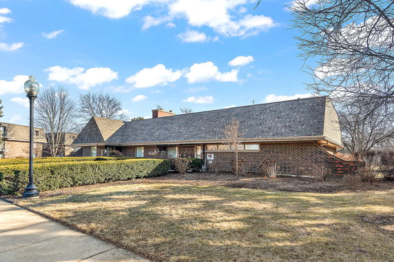 Front view of a single-story brick house with a sloped roof.