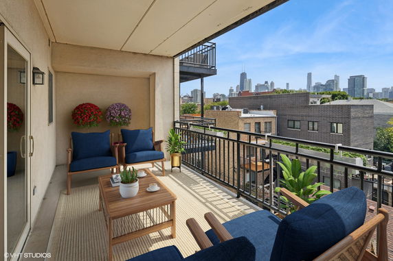 Outdoor view from a balcony with city skyline in the background.