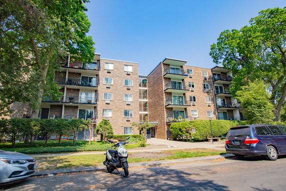 Front view of a multi-story apartment building with balconies.