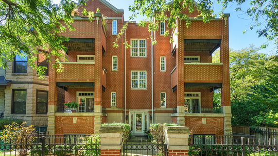 Front view of a multi-story brick building with balconies.