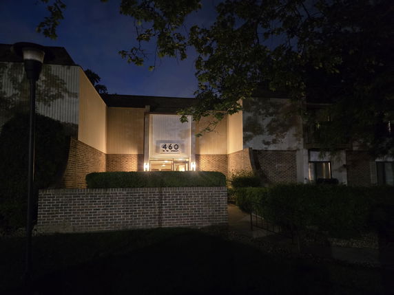 Front view of a building at night with illuminated entrance and address number 460.