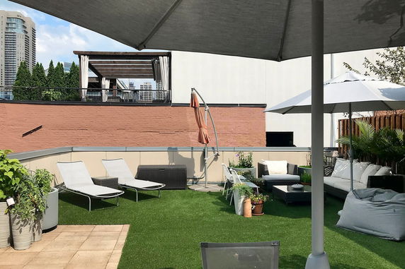Rooftop with lounge chairs, umbrellas, and seating area.