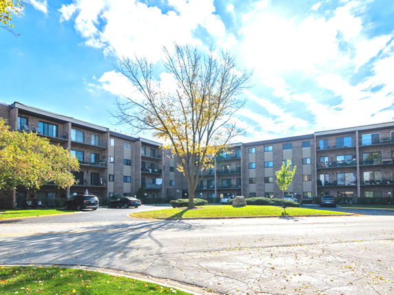 Front view of a multi-story apartment building with balconies.