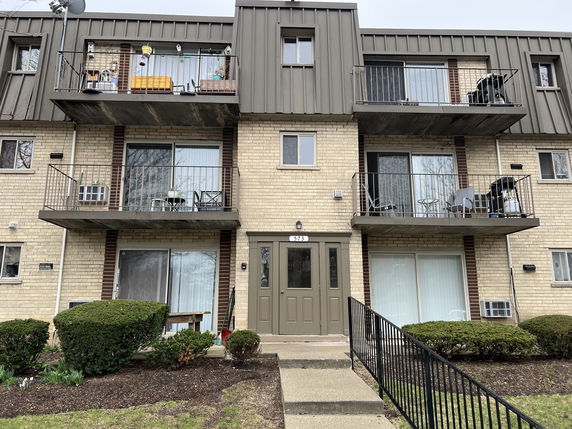 Front view of a multi-story residential building with balconies.