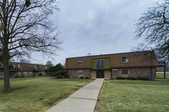 Front view of a two-story residential building with a gabled roof.
